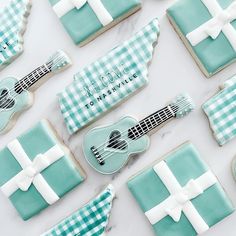 decorated cookies with blue and white designs are arranged in the shape of ukulele