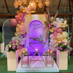 a stage set up with balloons, flowers and candles for a birthday party or celebration