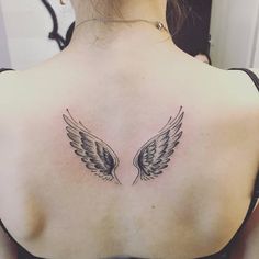 the back of a woman's shoulder with two wings on it