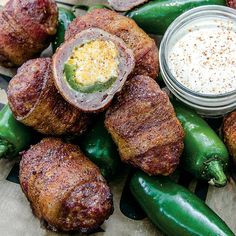 some green peppers and other food items on a plate with a small bowl of dip