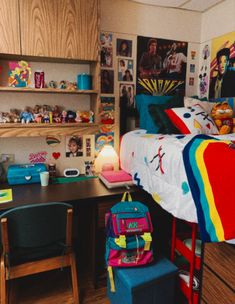 a room with a bed, desk and shelves filled with pictures on the wall behind it