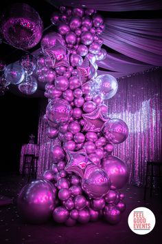 purple balloons are stacked high in the air