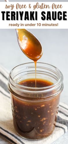 a jar filled with teriya sauce on top of a towel next to a spoon