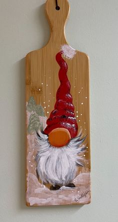 a wooden cutting board with a painting of a gnome on it's face and beard