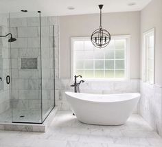 a large white bath tub sitting next to a walk in shower