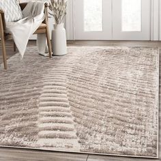 a beige rug with wavy lines on the floor in front of a chair and window