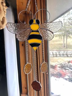 a glass and metal bee hanging from a window