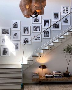 a living room with stairs and pictures on the wall