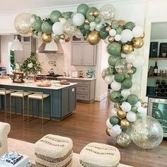 a living room filled with furniture and balloons in the shape of an arch on top of a kitchen island