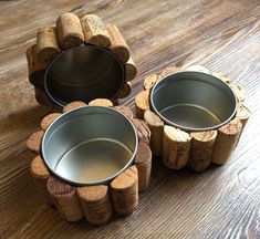 two metal cups sitting on top of some wine corks