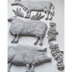 several clay animals and plants on a white surface