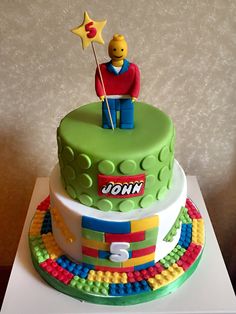 a lego cake with a man holding a star on top