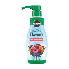 a bottle of fresh cut flowers on a white background