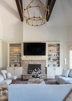 a living room filled with furniture and a flat screen tv mounted on the wall above a fireplace