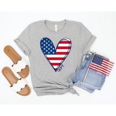 "USA Shirt, 4th of July Shirt Women, July 4th Tshirt, Fourth of July Tee, Merica Shirt, Red White Blue, American Flag Shirt, Memorial Day Tee This 4th of July shirt feels soft and lightweight, with the right amount of stretch, and is comfortable and flattering. The design features a cute American Flag heart with the word USA along the side. All inks used to print are water-based and eco-friendly. Sizing is UNISEX. It will fit a little more loosely and longer than your typical women's tee (great Merica Shirt, Blue American Flag, Freedom Shirts, 4th Of July Shirt, 4th Of July Outfits, American Flag Shirt, Usa Shirt, Patriotic Shirts, Flag Shirt