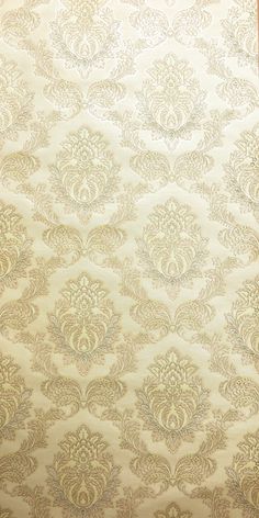 an old wallpaper pattern with gold and white designs on it's edges, as well as the background