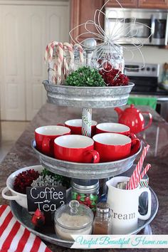 a three tiered tray filled with cups and candy canes on top of a table