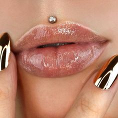 a woman with gold and white nail polish on her lips