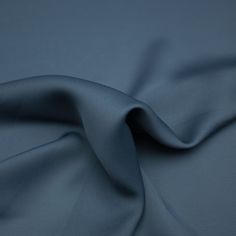 a close up view of the fabric on a plain blue cloth, with very soft folds