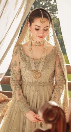 a woman in a wedding dress standing next to a window