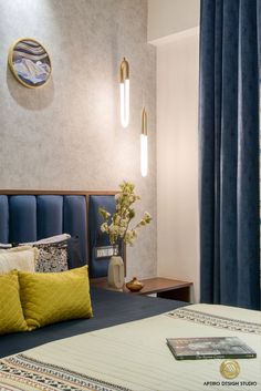 a bed with blue and yellow pillows in a bedroom next to a wall mounted clock