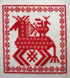 a red and white cross stitch pattern with a horse on it