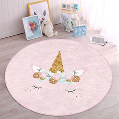 a pink rug with gold glitter unicorns and flowers on the floor next to a stuffed animal