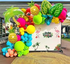 a bunch of balloons that are in front of a sign