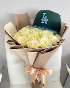 a bouquet of white roses and a los angeles dodgers cap