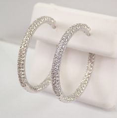 14K White Gold Diamond Hoop Earrings. These earrings are set with one hundred and eight genuine Round Brilliant Diamonds in EACH earring. These diamonds are H color, SI1 clarity and weigh a total of 1.75 carat. These earrings are 14K White Gold and weigh a total of 8.2 grams. These earrings are for pierced ears and measure 29 mm in diameter. These earrings will be accompanied by an appraisal written by a GIA Certified Diamond Grader with the retail replacement value of $4,895.00. I will ship these earrings promptly in a gift box. ADDITIONAL REQUESTS If you would like to see more pictures of this item, please let us know and we would be happy to provide them for you. Please contact us with all questions, we are here to help. Fine Jewelry Hoop Earrings With Pave Setting, Formal Hoop Jewelry With Pave Setting, Hoop Earrings With Diamond Cut Cubic Zirconia, Wedding Hoop Earrings With Pave Setting Round Cut, White Gold Hoop Jewelry With Pave Setting, Sterling Silver Hoop Jewelry With Vvs Clarity, Luxury Hoop Earrings With Brilliant Cut, Sterling Silver Hoop Diamond Earrings, Dazzling Hoop Earrings With Pave Setting For Formal Events