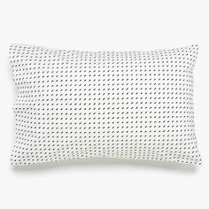 a white pillow with black dots on the front and back, against a white background