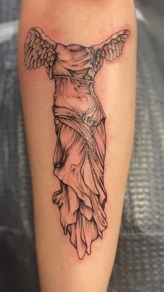 a tattoo with an angel on the back of it's leg, and wings