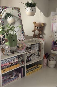 a white desk topped with lots of clutter and a teddy bear sitting on top of it