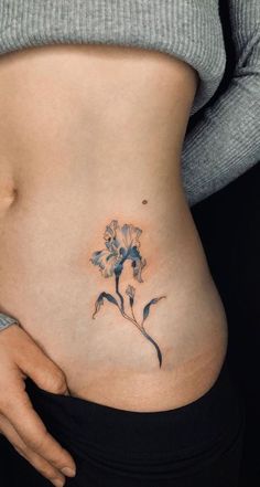 a woman's stomach with a flower tattoo on her belly and the bottom part of her tummy