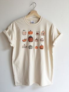 Hand Printed and Hand Drawn! This is a 100% cotton screen printed t shirt with a hand drawn illustration showing many varieties of pumpkins, like Lumina, Sugar,Cinderella, Connecticut Field and Jack be Little.  It's perfect for fall!  The shirt shown here is Natural and printed in orange and black ink.  // PROCESS:  All of our items are individually hand printed by either me or my dad, which can lead to slight variations in placement.  The ink is heat cured and will not fade over time.   Since o Screen Print Shirt, Screen Printing Shirts, Pumpkin Shirt, Drawn Illustration, Whistler, Clothes Gift, Print Shirt, Halloween Tshirts, Outfits Casuales