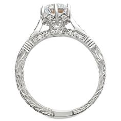 The gorgeous, picturesque details in this antique style diamond engagement ring are breathtaking! The channel pave set diamonds accented with mil-grain through out the ring and hand engraved with striking scroll work make this engagement ring a unique setting for the unique bride to be. The ring can hold a round center stone between 6.5mm to 7.0mm (1.00ct to 1.25ct) and the stone is secured with 6 prongs. This ring has a total weight in diamonds of 0.19 ct, excluding the center stone, with a qua Wedding Diamond Ring With Milgrain, Milgrain Round Cut Wedding Ring, Elegant Milgrain Engraved Ring For Anniversary, Elegant Engraved Milgrain Ring For Anniversary, Classic Engraved Promise Ring With Intricate Design, Luxury Wedding Diamond Ring With Side Stones, Luxury Milgrain Rings, Round Cut Diamond Ring With Milgrain Detail, Heirloom Wedding Diamond Ring With Pave Setting