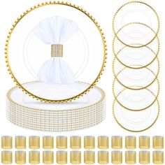 a set of gold and white plates, napkins, and place settings for a wedding ceremony