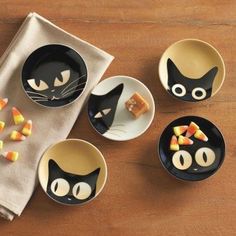 black cat plates and bowls with candy on them