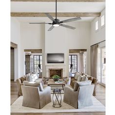 a living room filled with furniture and a flat screen tv mounted on the wall above a fireplace