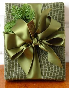 a present wrapped in green paper with a bow