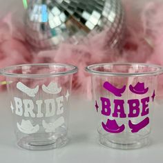 two shot glasses with the words bride and babe painted on them, sitting next to each other