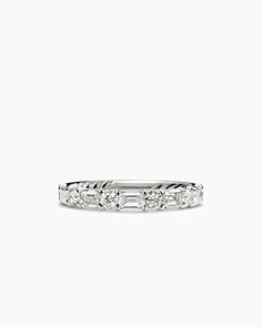 a white gold wedding band with baguettes and diamonds on the side, set in 18k white gold