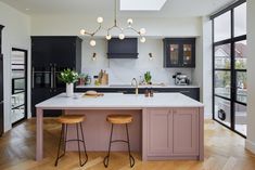 a kitchen with two stools in front of the island and an open floor plan