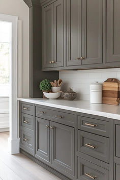 a kitchen with gray cabinets and white counter tops