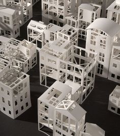 a group of white model houses sitting on top of a black floor