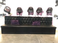 a black leather couch with purple pillows and chairs on it's backrests