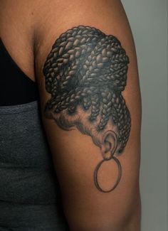 a woman's arm with a black and grey tattoo design on her left shoulder