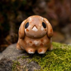 a small toy sitting on top of a moss covered rock