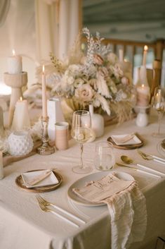 the table is set with place settings and candles