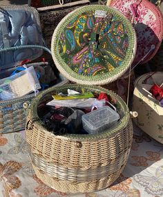 two wicker baskets sitting next to each other on top of a table covered in fabric